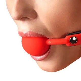 Röd gagball i silikon med justerbart spänne, använd på en person