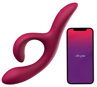 Den mörkrosa We-Vibe Nova 2 Rabbitvibrator, med en böjd, flexibel klitorisstimulatordesign, visas bredvid en smartphone som visar We-Vibe-appen.
