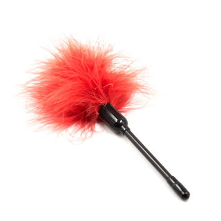 IntoYou 10-Delar Bondage Kit har en röd fjäderduk med ett svart handtag, elegant presenterad på en vit bakgrund.