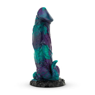 Mythical Mates Dragonfly Dildo 22 cm är en blå och lila dildo med fantasytema tillverkad av kroppssäkert silikon, med en tentakelliknande bas med sugkopp, elegant presenterad på ett svart stativ.