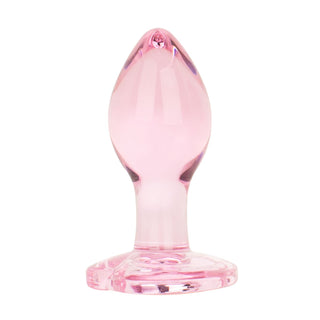 En hjärtformad buttplug (7 cm) i rosa glas med en utsvängd bas står upprätt mot en vit bakgrund - perfekt för temperaturlek och elegant intimitet.