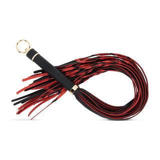 Flogger Piska I PU-Läder 64 cm har en svart och röd PU-läderdesign med flera svansar och ett guldringhandtag - ett perfekt elegant tillskott till din bondage-samling.