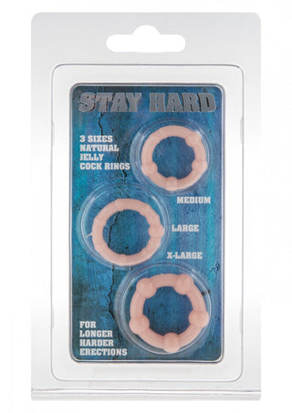 Stay Hard 3-Pack Penisring innehåller mellanstora, stora och X-stora rosa ringar i en plastförpackning designad för ökad uthållighet och intensivare erektioner, mot blå bakgrundstext.