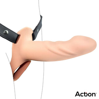 Action Strap-On Hollow Dildo L har en beige realistisk dildo med en svart sele, elegant visad i profil på en vit bakgrund. Varumärket Action visas längst ner till höger, och betonar dess premium silikonkvalitet.