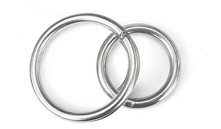 Två sammankopplade metallringar på vit bakgrund, som liknar delar av Strap-on Set med 3 Silikondildos, med en ring något mindre än den andra.