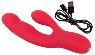 En röd silikon Thumping Rabbitvibrator med dubbla stift och texturerade detaljer visas bredvid en svart USB-laddningskabel, med kontrollknappar på ytan och en bultande funktion.