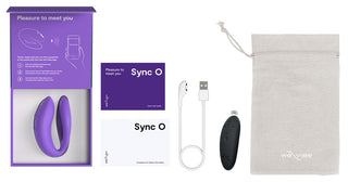 En öppnad förpackning avslöjar WE-Vibe Sync O Vibrator, en lila bärbar enhet med instruktionshäften, en USB-laddningskabel och en svart fjärrkontroll i en beige förvaringsväska. Lila accenter som säger "Nöjet att träffa dig" framhäver dess sömlösa ihopkoppling med We-Vibe-appen för förbättrade upplevelser.