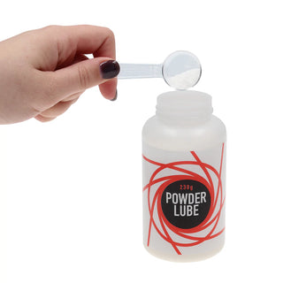 Häll en pulveriserad substans i en genomskinlig flaska märkt "Powder Lube" med en röd virveldesign, perfekt för dem som letar efter en anpassningsbar textur.