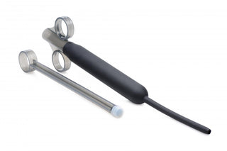 En handskförsedd hand håller en Deep Shot Launcher, en svart och silver enhet gjord av kroppssäkert silikonmaterial, tillsammans med ett metallrör med två ringar på en orörd vit bakgrund.