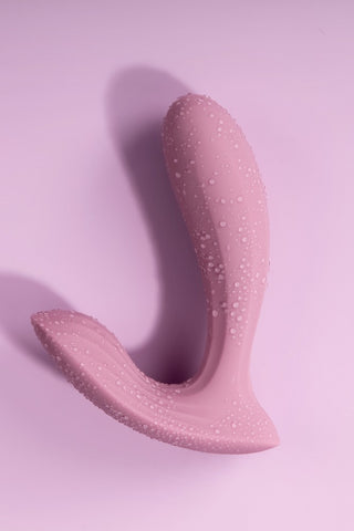 Svakom Erica, en trosvibrator med ergonomisk design, har en texturerad silikonyta som inbjuder till utforskande mot en rosa bakgrund.