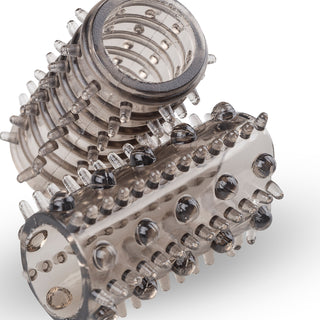 En närbild visar tre diagonala, strukturerade ärmar från Penis Sleeve Set. Varje hylsa har rader av små, rundade knoppar för varierad njutning och förbättrat grepp, placerade mot en vanlig vit bakgrund för att understryka deras extra stimulerande fördelar.