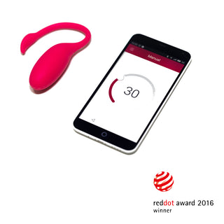 En rosa trådlös Magic Motion Flamingo - Vibrerande Ägg finns bredvid en smartphone som visar appstyrt ägg-gränssnittet, med Red Dot Award 2016-vinnarlogotypen längst ner, för att fira sin innovativa design.
