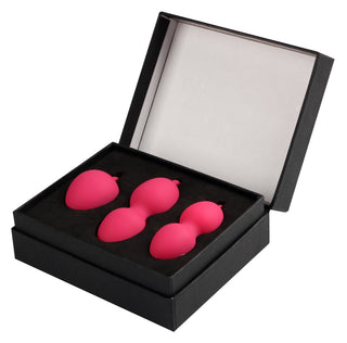 En öppen svart låda avslöjar tre rosa, päronformade Knipkulor inbäddade på ett lyxigt svart sammetsfoder.