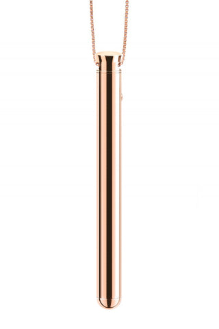 Le Wand Vibratorhalsband har ett elegant, minimalistiskt metalliskt roséguld cylinderhänge på en kedja, visat mot en vit bakgrund.