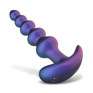 En lila analplugg i silikon med flera pärlor, ett ergonomiskt handtag och en touch av Vibrerande Analkulor i Galaxyfärg. Ställd mot en vit bakgrund erbjuder den olika vibrationslägen och bekvämligheten med en fjärrkontroll för enkel kontroll.
