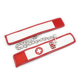 Ohmama 3-delade Nurse Bondage Set innehåller ett rött och vitt pannband med ett sytt korsemblem, idealiskt för rollspel för sjuksköterskor, och kommer med en silverkedja med ett fäst nyckellås.