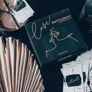 Ett bord har Love Battleship Premium Edition, med dess konstnärliga linjekonstlåda. Metalliska fläktdekorationer och Opennmity-kortpaket skapar en elegant, intim atmosfär, perfekt för att utforska detta spännande spel med sextema.