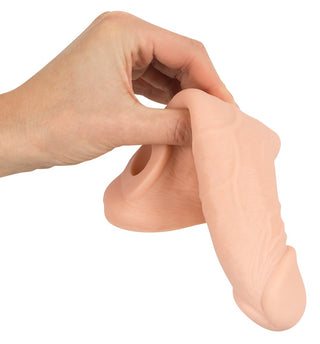 En hand håller en realistisk silikonprotes med öppen ände och detaljerad yta, som liknar en Penisförlängare - Nature Skin - Penis Sleeve.