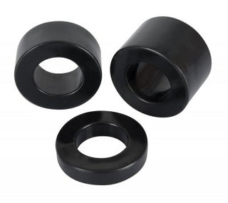 Tre "Penisring - Rebel MBS Ball Stretching Kit" svarta cylindriska gummigenomföringar med hål visas separat på en orörd vit bakgrund, perfekt för pungsträckare användning.