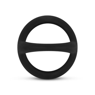 Den svarta Flexibel Silikon Pung & Penisring, med en rattform med en slät silikonfinish och en horisontell stång inuti, vilar på en vit bakgrund.