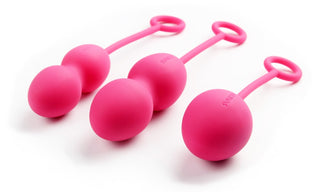 En uppsättning med tre rosa geishakulor från Knipkulor - 3 Set I Silikon Nova, var och en med ögla handtag, vilar elegant på en vit bakgrund.