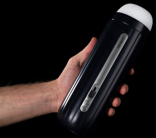 En hand håller en snygg, svart Hannes Neo Svakom-enhet med kontrollknappar för interaktiv njutning mot en djupsvart bakgrund.