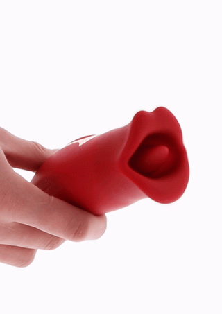 En hand håller Toyjoy The Kisser, en röd silikonleksak designad som en fisk med öppen mun.