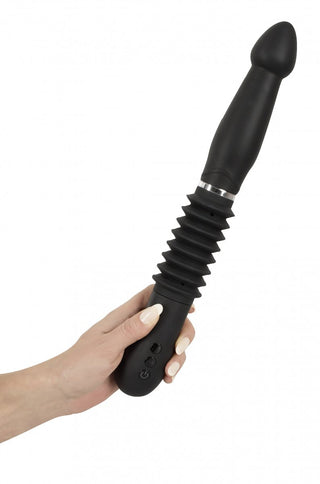 En hand visar You2Toys Thrust Vibrator, med en räfflad mitt och släta ändar, som framhäver dess starka vibrationer för ökad njutning.