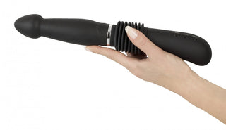 En hand som håller You2Toys Thrust Vibrator, en svart personlig massageapparat med kraftfulla vibrationer och kontrollknappar.