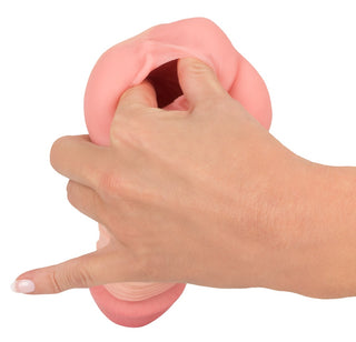 En hand sträcker en rosa silikon Penisförlängare / Vagina - 2 i 1 mot en vit bakgrund.