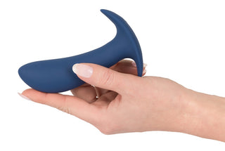 En hand som håller en blå Vibrerande buttplugg/prostata-enhet med en böjd silikondesign och en handtagsliknande förlängning, utrustad med fjärrkontrollfunktion.