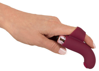 En hand håller den eleganta, ergonomiska Finger Vibrator Med Bullet i vinrött, designad för sensuell massage och ultimat avslappning.
