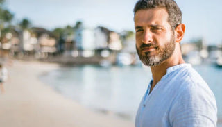 Självsäker man vid stranden – symbol för manlig hälsa och välbefinnande genom prostatastimulering och P-punktsmassage.