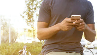 Man använder sin smartphone utomhus – symbol för manlig hälsa och information om hur erektionen fungerar