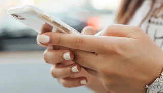 Kvinna håller en smartphone – sexting, digital intimitet och flirt via mobilen