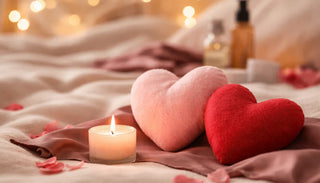 Stämningsfull bild med hjärtformade kuddar, tända ljus och mjuk belysning som symboliserar närhet, relation och intimitet.