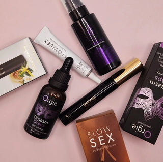 Olika lusthöjande produkter som orgasmgel, stimulerande droppar och klitorisbalsam från märken som Orgie, Slow Sex och Bijoux Indiscrets mot rosa bakgrund
