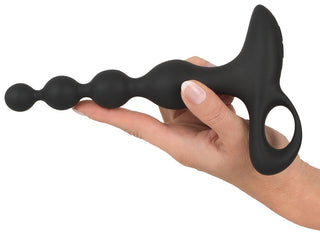 Hand som håller en Uppladdningsbar Analkulor med en böjd, pärlformad design och ett cirkulärt handtag.