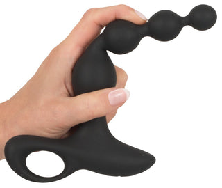 En hand håller den snygga Uppladdningsbaren Analkulor, en svart prostatamassager i silikon med öglehandtag och pärlliknande design.