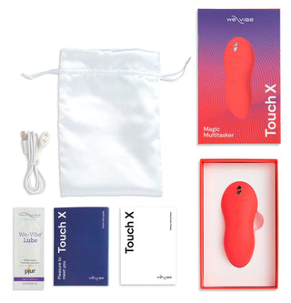 We-Vibe Touch X-setet innehåller en röd vattentät vibrator, en påse, USB-kabel, ett glidmedelspaket och manualer, allt visas mot en vit bakgrund.