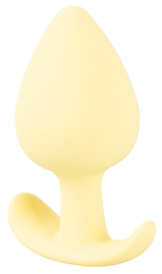 Cuties Mini Buttplug Gul, ett gult droppformat föremål gjord av kroppssäkert silikon, har en böjd bas och visas elegant mot en vanlig vit bakgrund.