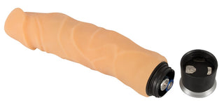 En beige silikonvibrator med strukturerad yta, med batterifacket öppet och locket placerat bredvid på en enfärgad bakgrund.