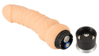 En hudfärgad vibrator tillverkad av Nature Skin-material, 18 cm lång, med batterifacket öppet och locket placerat bredvid.