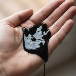 Eros Black Touch 150 ml, en tjock, svart gel-liknande produkt med en glansig textur som visas i en liten portion.