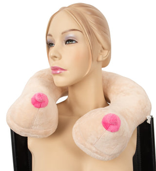 En mannequin bär Rolig Bröst Nackkudde - en unik nackkudde formad som bröst med rosa bröstvårtor, perfekt som rolig present till resan.