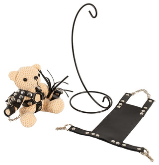 BDSM Nalle i Mini-Gunga har en virkad björn i en svart lädersele, sittande på ett svart metallstativ med matchande tillbehör och en lekfull mini-sexgunga - ett spännande tillägg till varje unik samling.