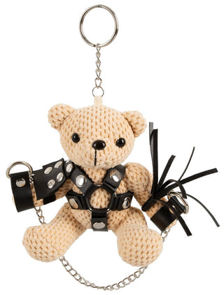 BDSM Nalle i Mini-Gunga: Virkad teddybjörn nyckelring i svart lädersele, sittande i en minigunga med nitar och kedjor. En finurlig samlarfavorit för dig som älskar lekfull, unik design.