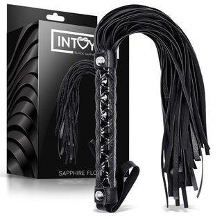 Black Sapphire Vegan Flogger, tillverkad av veganskt läder med mjuka remmar och en texturerad handtag, visas bredvid en förpackning märkt INTOY Black Sapphire Vegan Flogger.