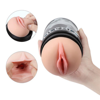 En hand håller i SHEQU Classic Vaginamasturbator, en realistisk manlig masturbator utformad som en vaginaformad hylsa.