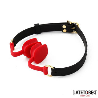 LatetoBed Force Mouth Gagball: Röd silikonboll med svart justerbart band och guldhårdvara från LatetoBed BDSM Line. Perfekt som ett exklusivt BDSM-tillbehör.